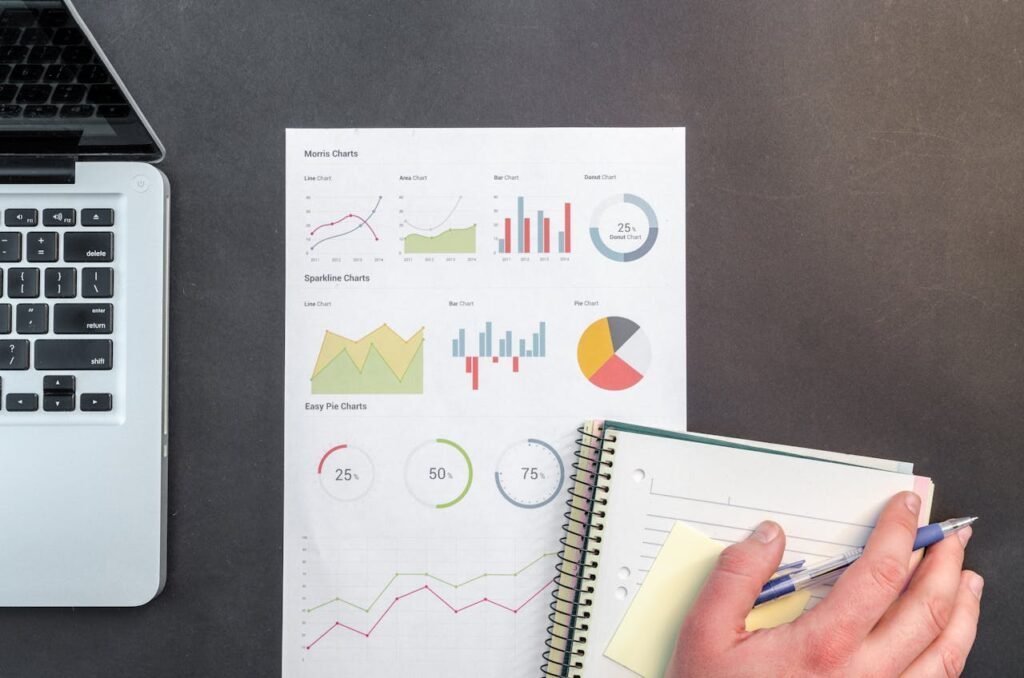 pexels-photo-669610 Overhead view of a business desk with charts and a laptop, ideal for data analysis concepts.